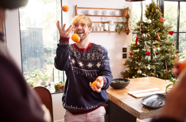 Een man die met fruit aan het jongleren is. Fruit kan gegeven worden als gezonde kerstcadeaus